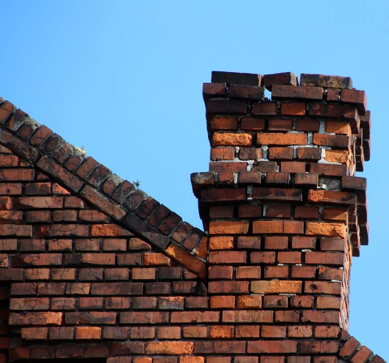 Damaged chimney on an Madison Heights home showing cracks and missing mortar